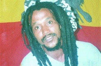 Portrait of Kaya with dreadlocks against a colourful background