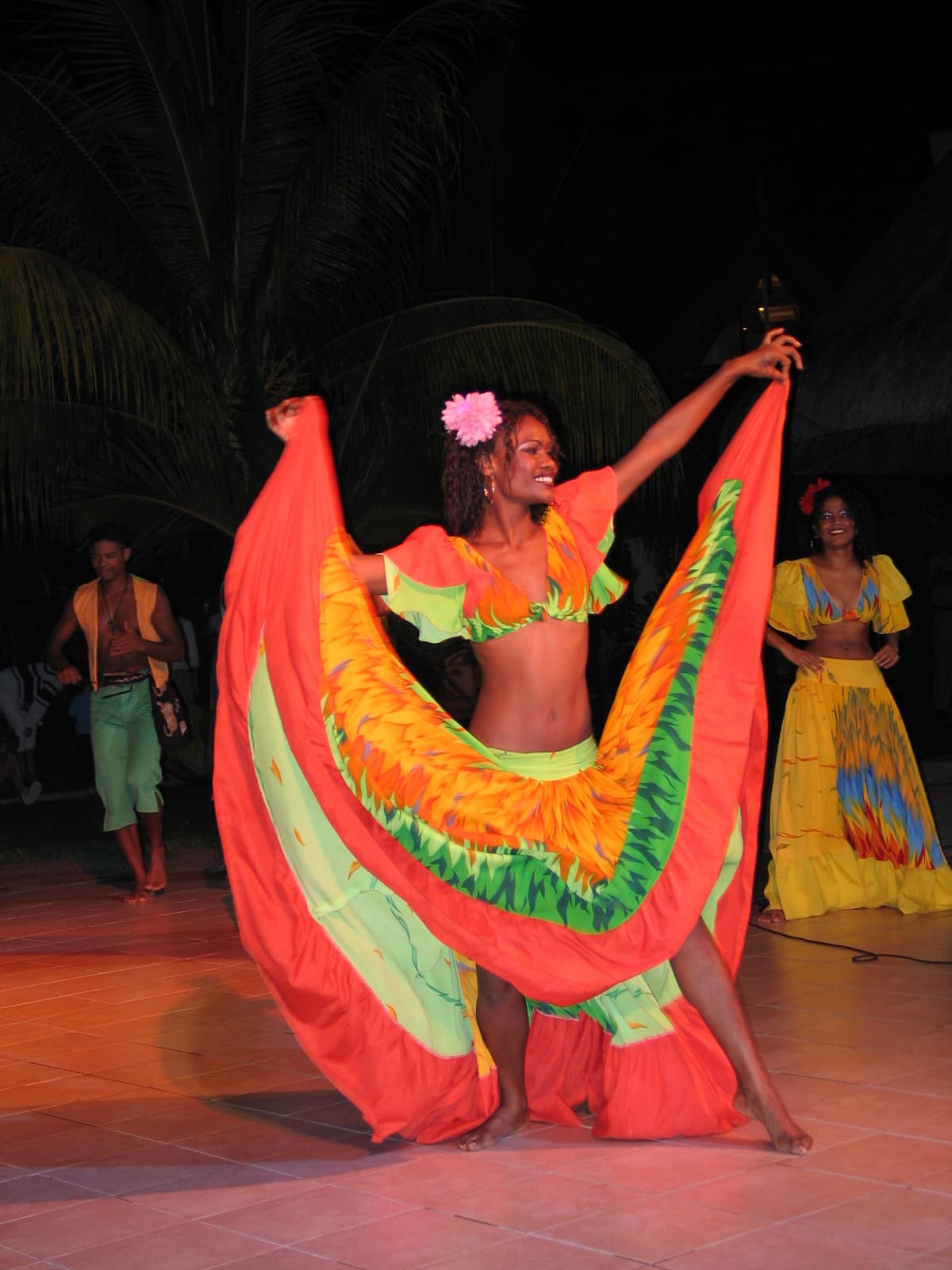 Sega dancer spreading a bright orange and yellow skirt during an evening performance
