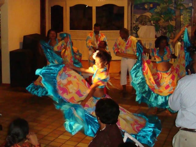 Sega dancers in blue and yellow dresses performing indoors in Mauritius